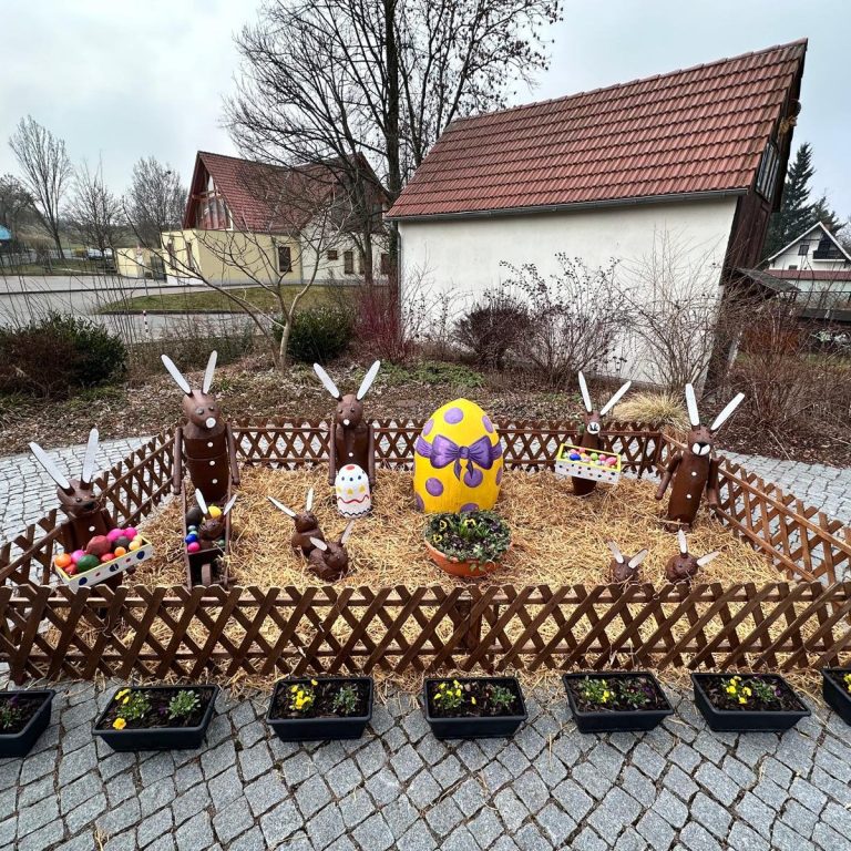 Zwei Personen arbeiten gemeinsam an einem Holzfass. Bunte Lichter im Hintergrund.