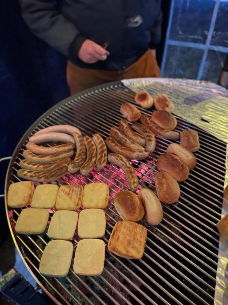 Gegrillte Würstchen und Gebäcke auf einem Grill.